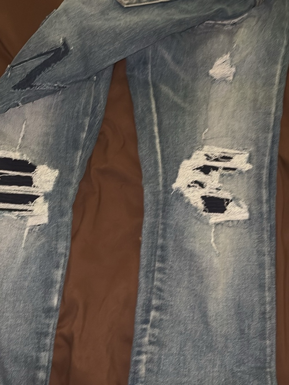 AMIRI Light Blue Distressed Ripped Jeans with Black Patch Details